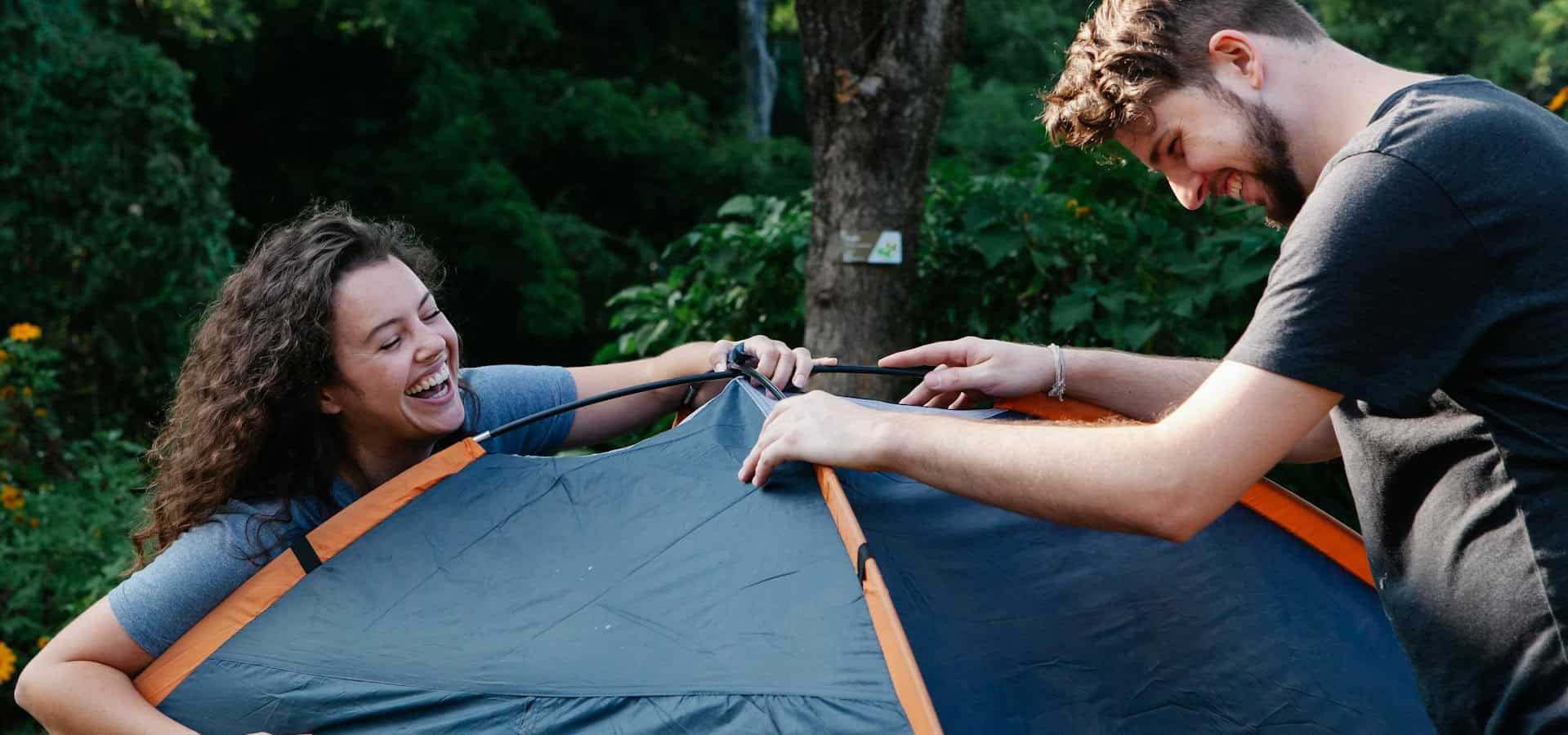 Man and woman setting up a tent